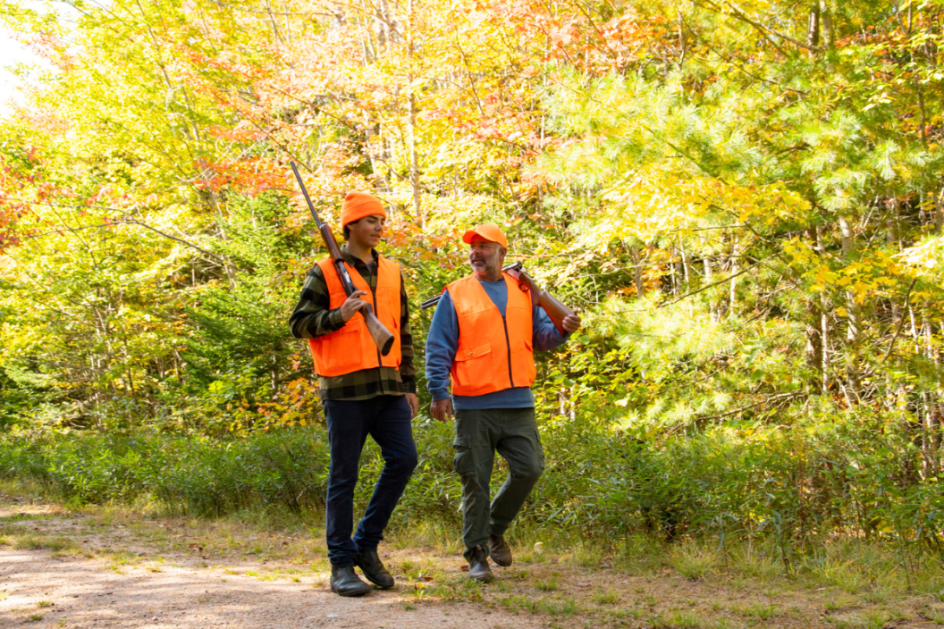 A father and son hunting in the fall.