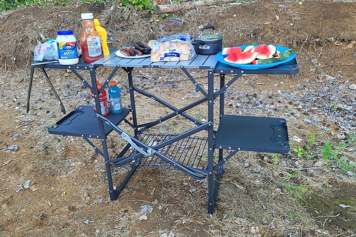 The GCI Outdoors Slim-Fold Cook Station set up in the woods.