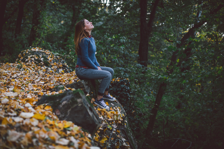 Beautiful woman enjoying nature in green forest