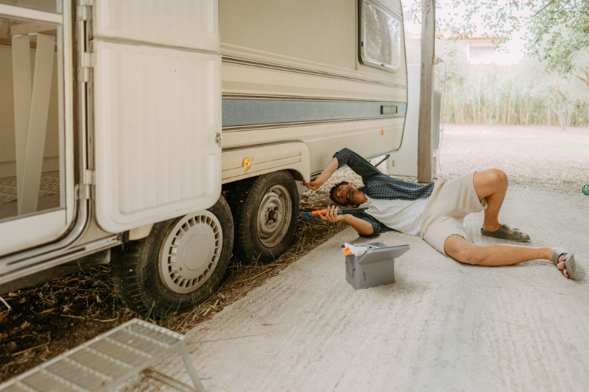 Photo of a young man repairing and checking his recreational vehicle.