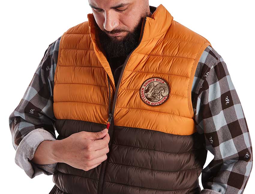 Man wearing a puffy vest from Magellan Outdoors with shiner beer logos