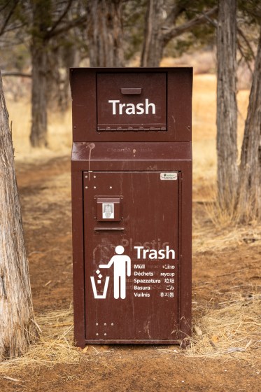Brown Trash Bin Among Trees At Trail Head in Zion National Park