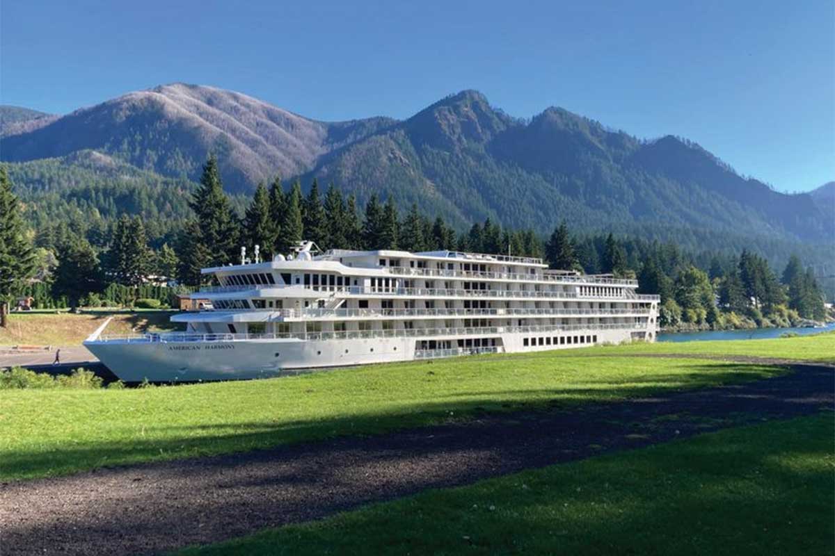 A white cruise ship with mountains in the background