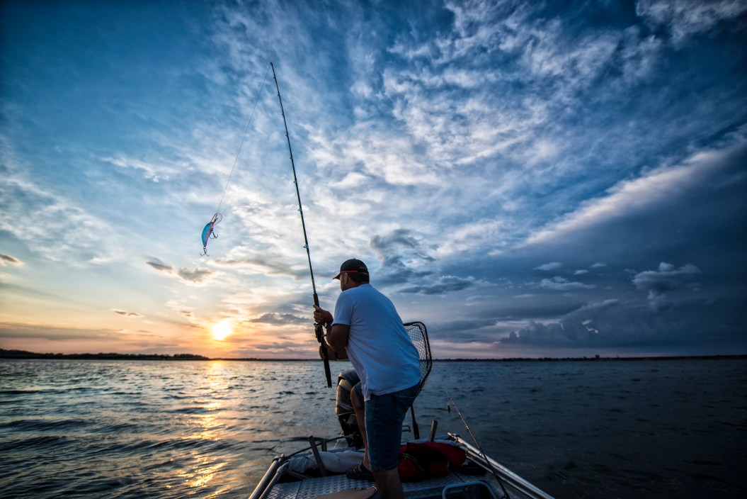 Angler Casting off a boat at sunset