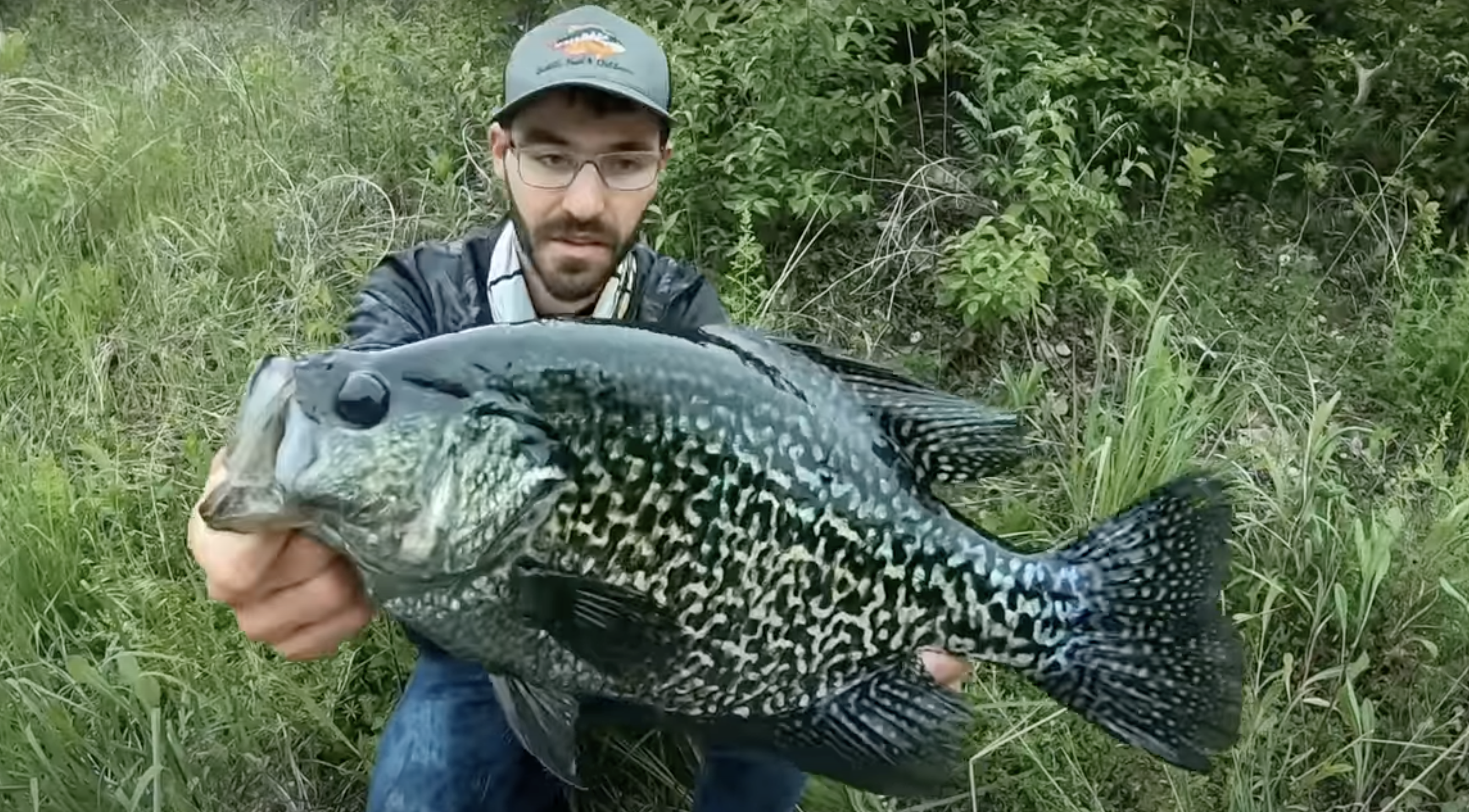 An angler holding a huge black crappie.