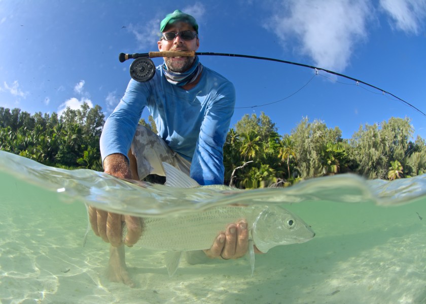 split-level image of fly fisherman with a bonefish in seychelles. self portrait.