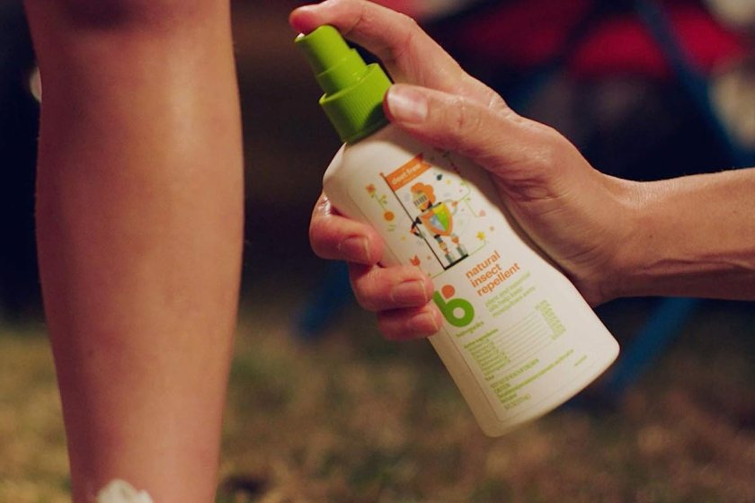 Close up on hand spraying Babyganics Insect Spray onto leg