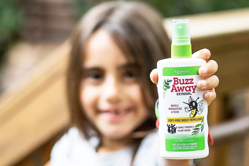 Child holding a bottle of Quantum Health Buzz Away Extreme Insect Repellent|