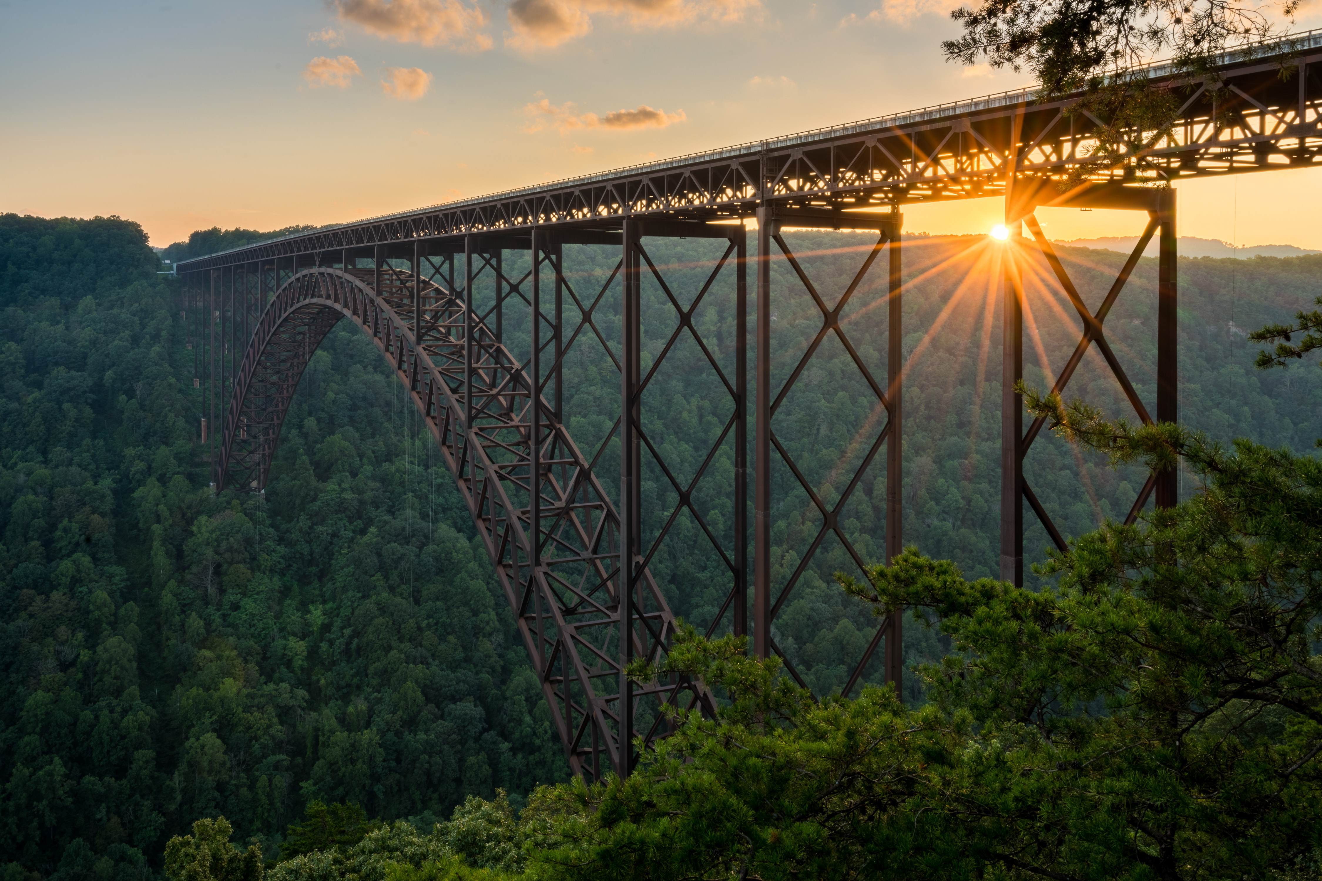 Setting sun behind the girders of the high arched New River Gorge bridge in West Virginia