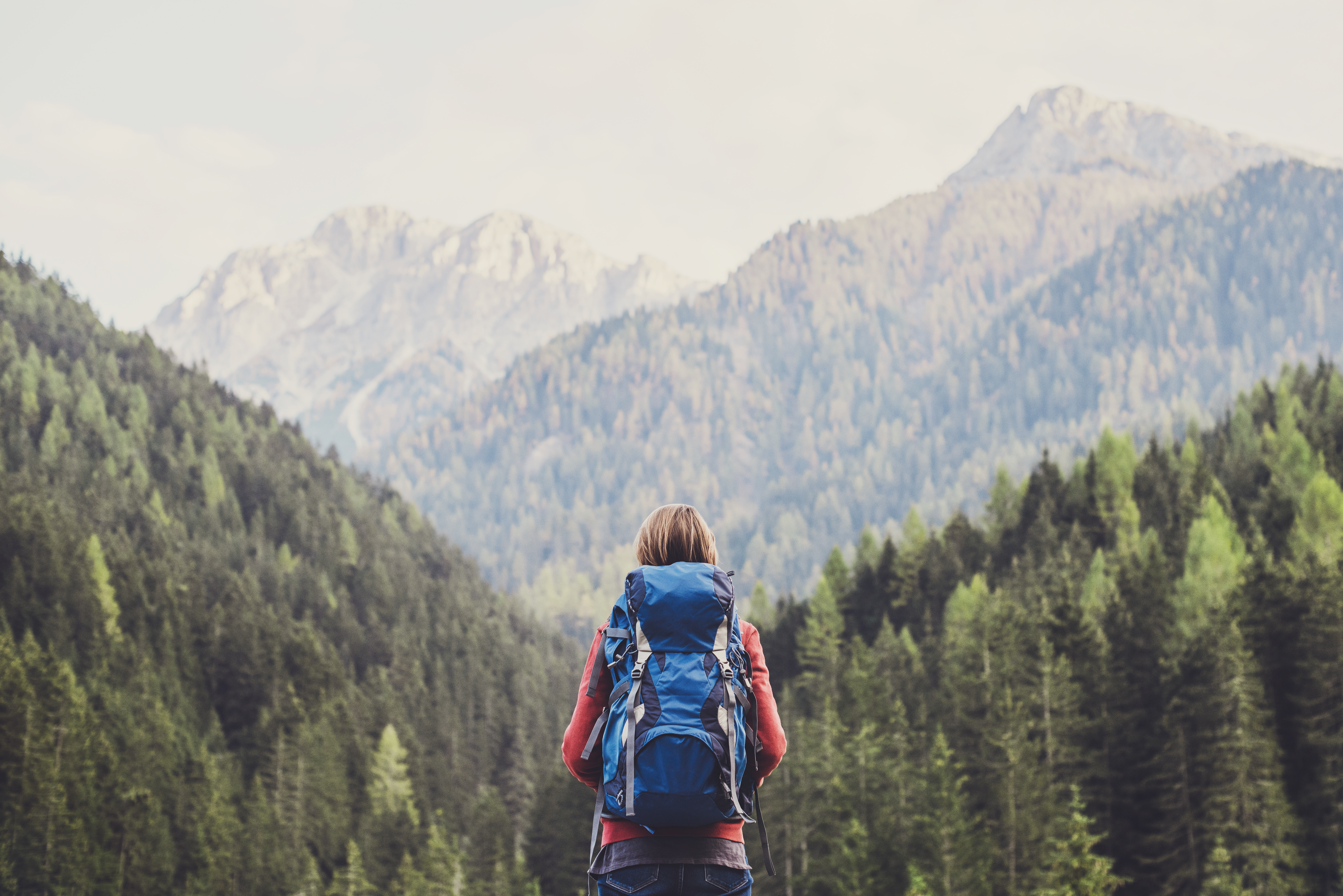 Young girl traveler on a walking route, active lifestyle, hiking and travel concept. Women looking at lake in winter