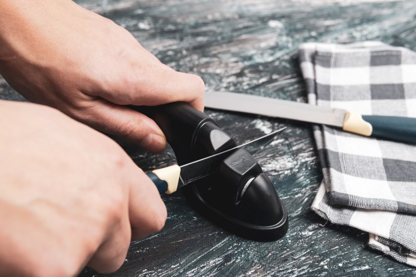 Man manually sharpens kitchen knives. Knife sharpening. The concept of caring for knife sharpness.