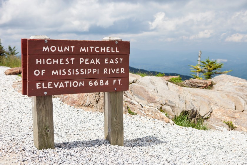 A sign at the top of Mt. Mitchell in North Carolina indicating it's the highest peak east of the Mississippi River.