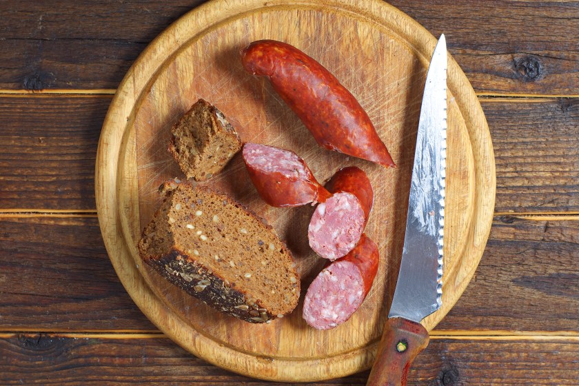 Homemade smoked sausage on a kitchen board, top view