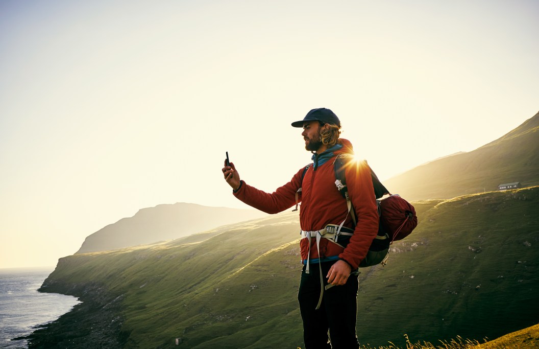 Shot of a young man taking pictures with his cellphone outdoors
