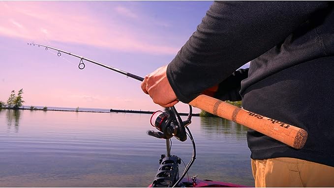 Someone holding the Ugly Stik above a body of water during a pink and blue sunset