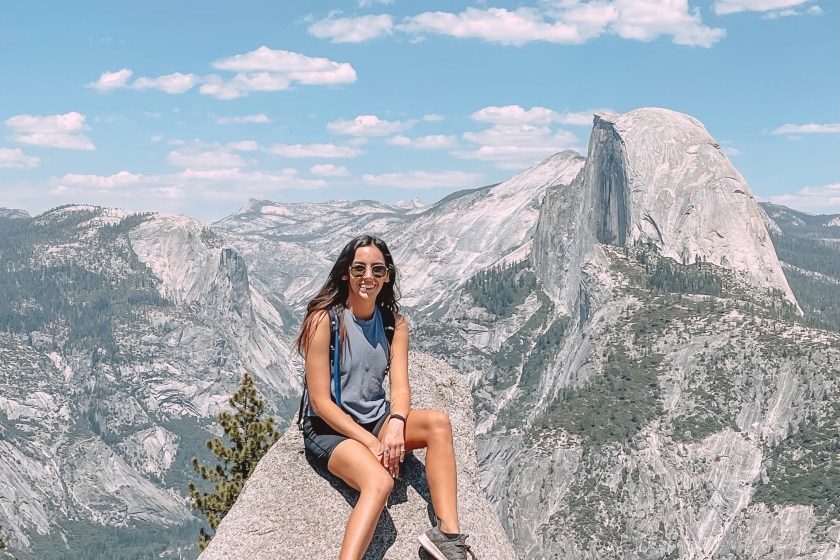 Author wearing a backpack and sitting on a rock in Yosemite National Park
