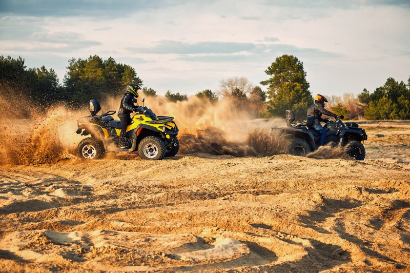 Racing powerful quad bike on the difficult sand in the summer.