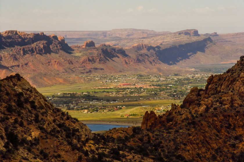 View over the town of Moab in Utah, USA, situated between sandstone ridges, as seen from the La Sal Mountains