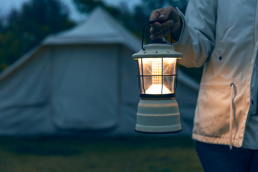woman with a lamp at the campsite