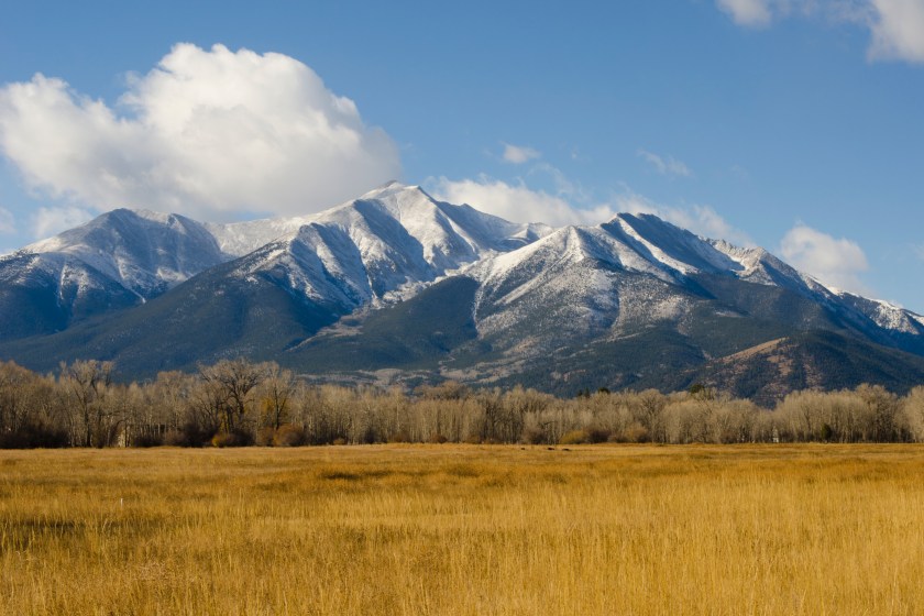 The first snow of the season is draped across the shoulders of Mount Princeton in the Collegiate Peaks Range of the Rocky Mountains near Buena Vista, Colorado. Fall colors are still visible in the hay field foreground, but winter is fast approaching.