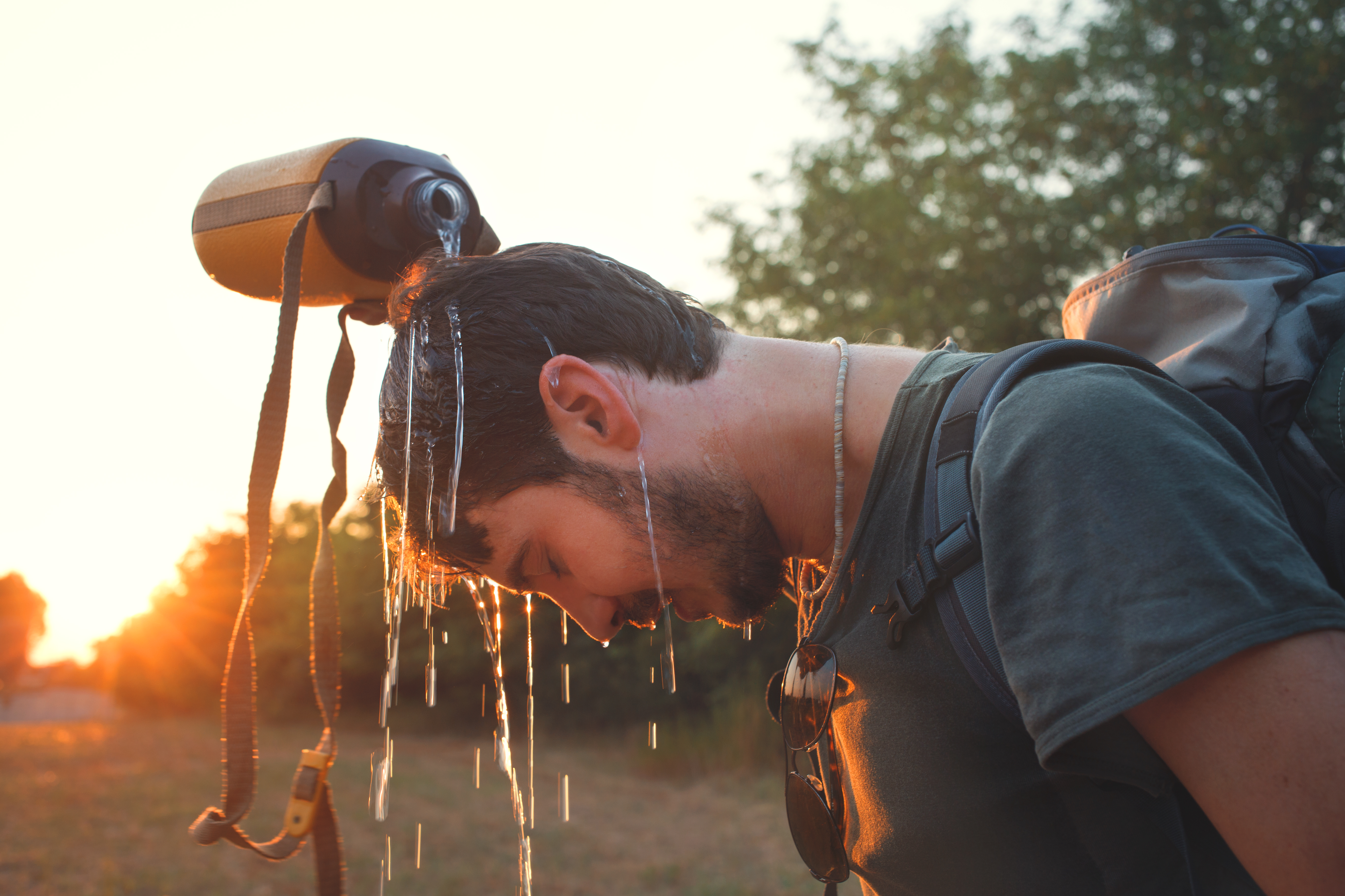 hiker Man dropping fresh water on his head