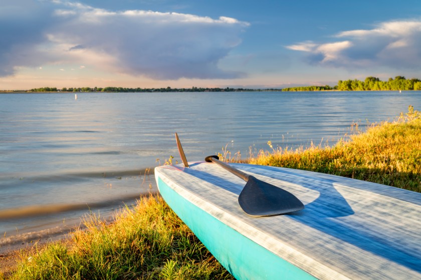 stand up paddleboard with a paddle on a lake shore in Colorado (Boyd Lake State Park), summer scenery. Colorado campsites