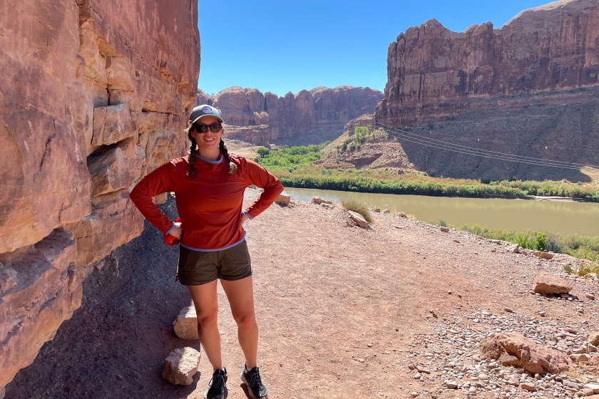 Author hiking in a canyon while wearing a burnt orange sun hoodie