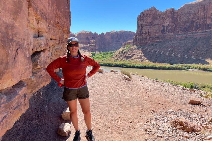 Author hiking in a canyon while wearing a burnt orange sun hoodie