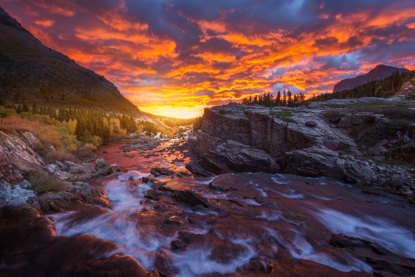 Fiery sunrise at Swiftcurrent Falls in Many Glacier, Glacier National Park, Montana