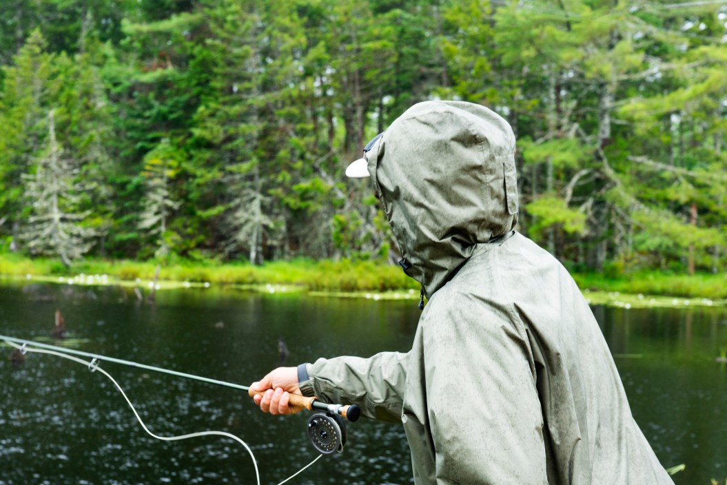 A fly fisher fishing in a summer rain storm