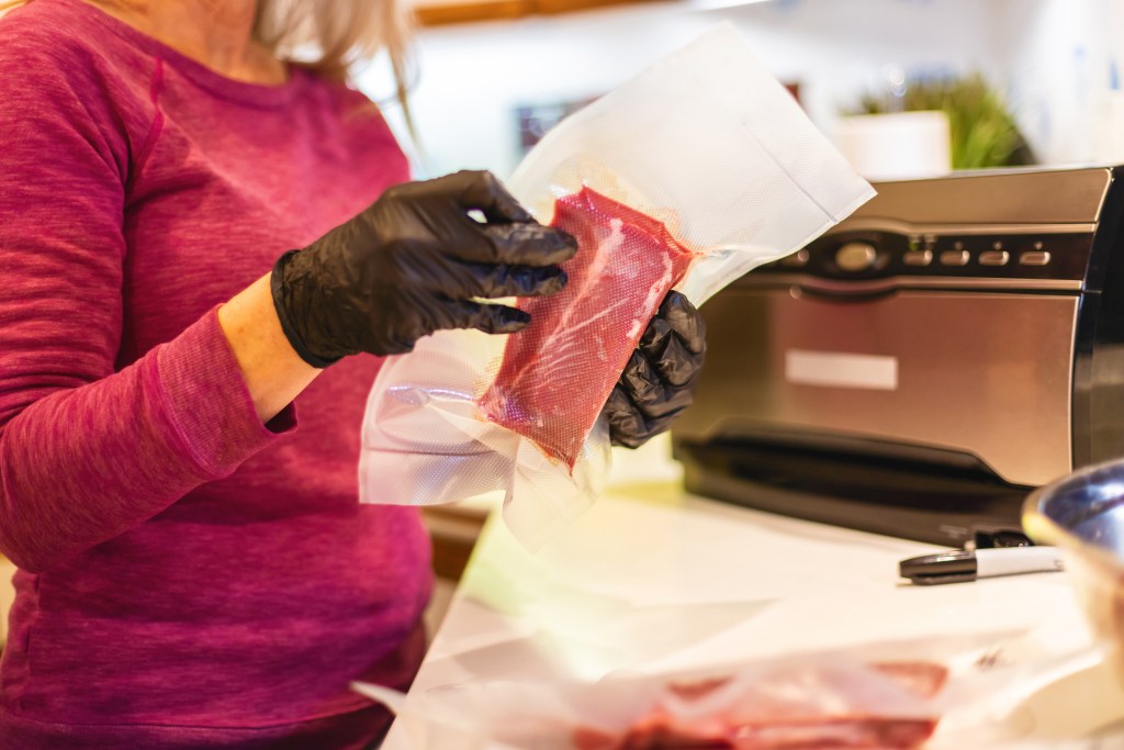 Grinding Meat into Burger and Steaks and Vacuum Sealing for Freezer Hunting in Western Colorado Following Hunting Harvest Processing Wild Game Mule Deer Meat Photo Series with Matching 4K Video Available (Shot with Canon 5DS 50.6mp photos professionally retouched - Lightroom / Photoshop - original size 5792 x 8688 downsampled as needed for clarity and select focus used for dramatic effect)