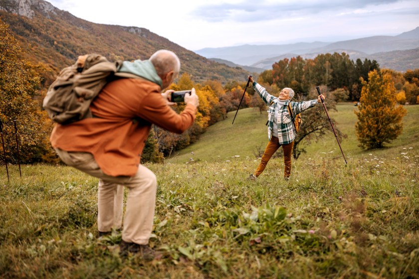 Senior man taking a photo of his wife on a hiking