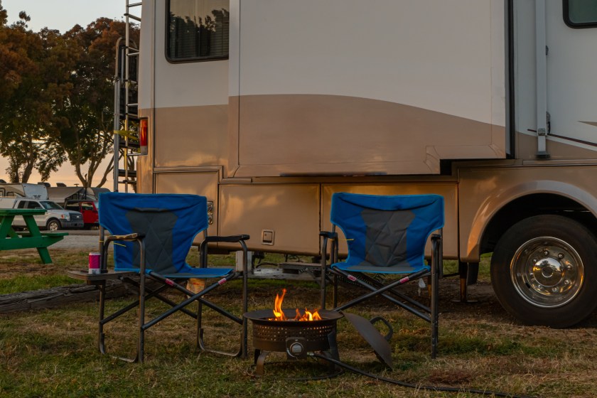 Chairs for sitting at a campfire at campsite next to Rv motorhome