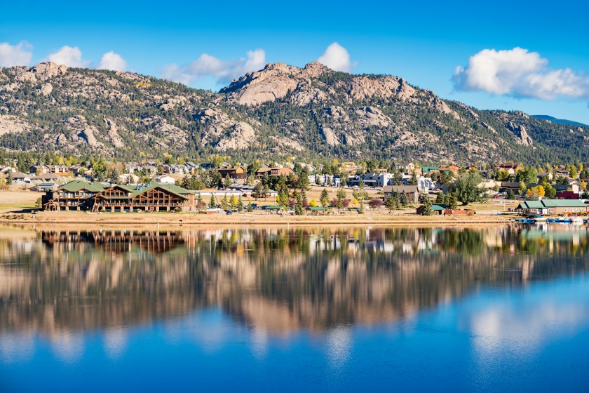 Stock photograph of the town of Estes Park reflecting in Lake Estes Colorado USA on a sunny day.