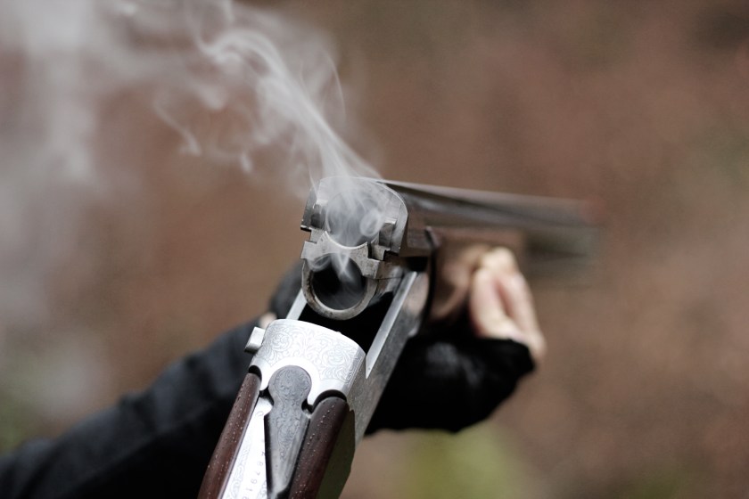 Closeup of a smoking traditional skeet shooting shotgun after shots fired.