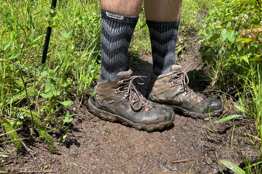 A pair of hiking boots on top of rainy mud