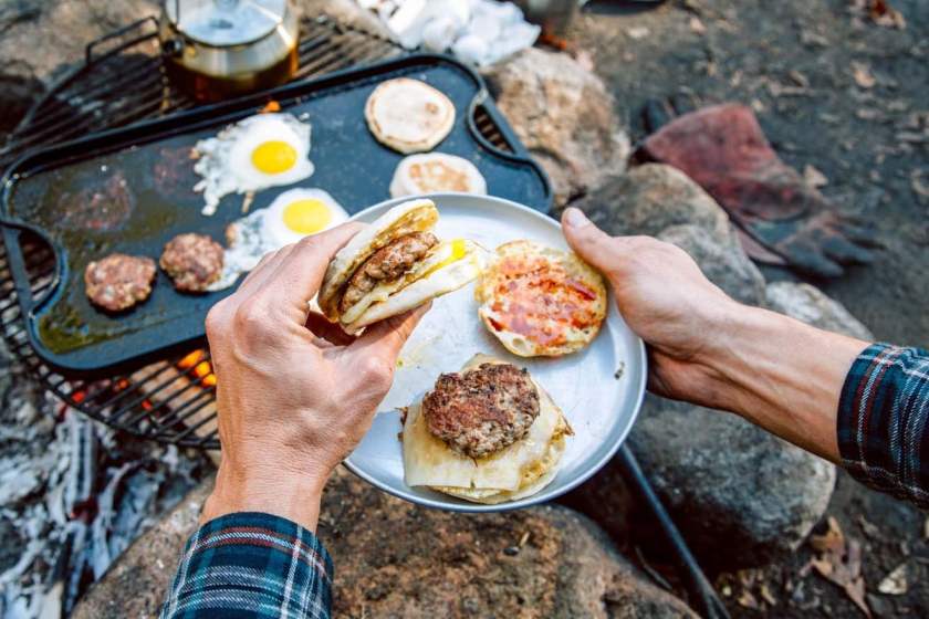 Egg and sausage breakfast sandwiches over a campfire sklillet 