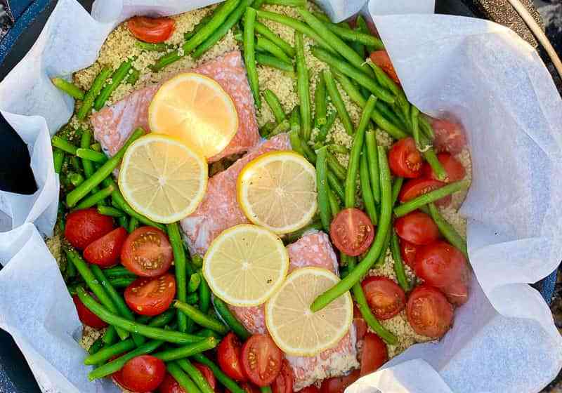 Salmon with green beans and tomatoes in a cast iron skillet