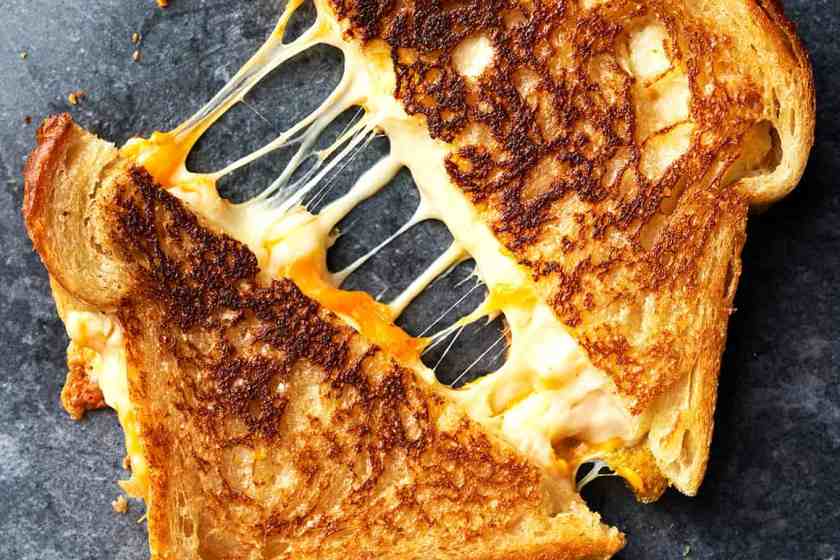 A grilled cheese sandwich being pulled apart