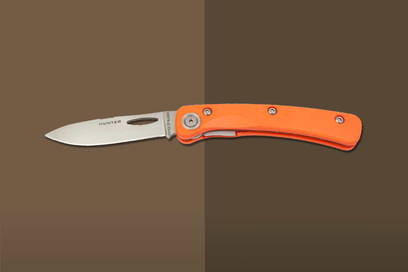 An orange knife handle with a silver blade on a brown background
