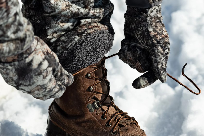 Person tying a snow boot while wearing ASIO Sherpa Lined Pants