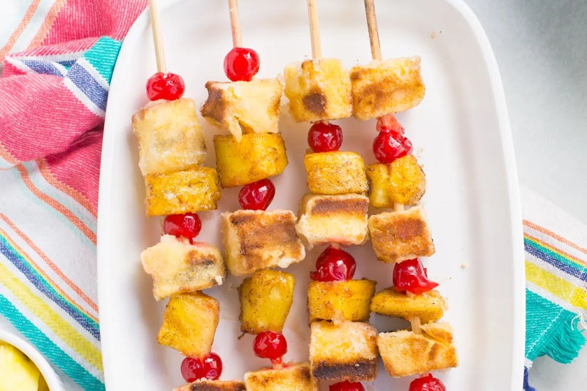 Pineapple kabobs on an ovular white tray