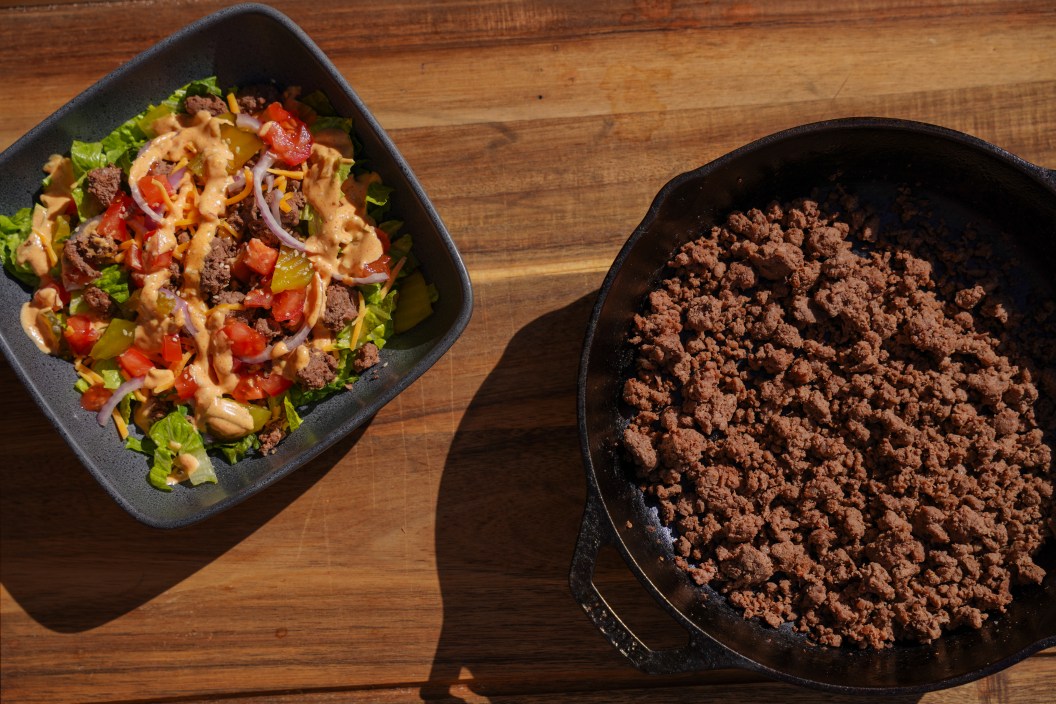 Tasty burger bowl sits next to a skillet of ground venison