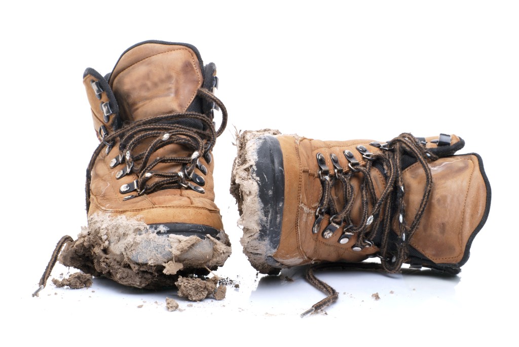 pair of dirty hiking boots on a white background