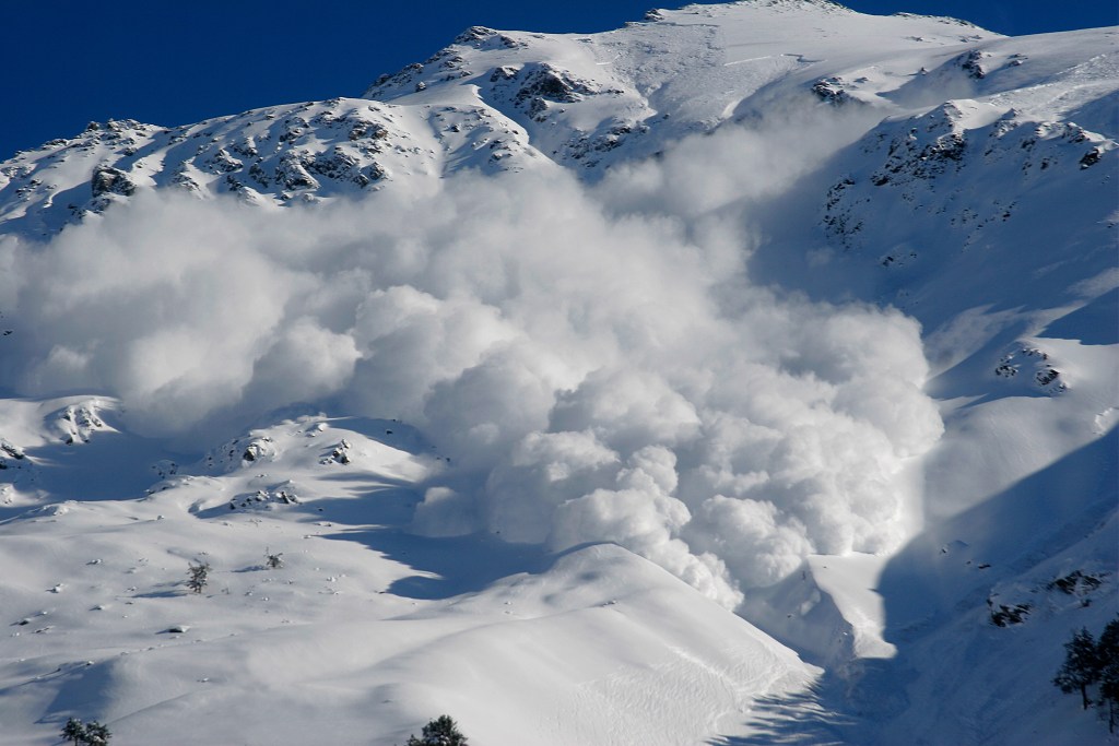 Dry snow avalanche with a powder cloud close to the village Terskol, Elbrus region