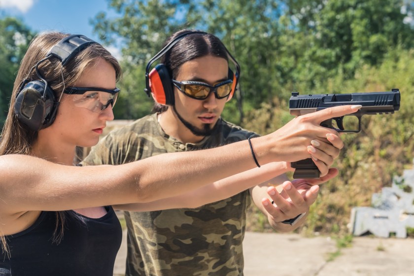 man showing a woman gun safety